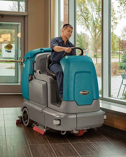 Office flooring solution cleaning with a ride-on floor scrubber maintaining clean commercial office floors.